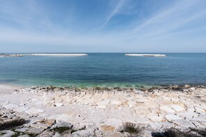 Un paysage côtier avec une plage de galets et une mer calme.