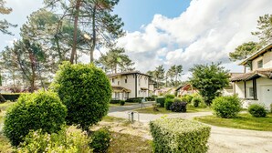 Un quartier résidentiel avec des maisons, une pelouse bien entretenue et un ciel dégagé.