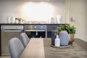Eine moderne Küche mit Esstisch, Stühlen und dekorativen Vasen.
