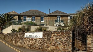 A stone building with a sign reading 'The Llanwnoroc.' - Llawnroc Hotel (Gorran Haven)