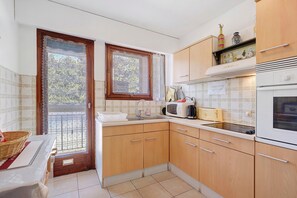 Una cocina con armarios de madera, microondas, tostadora y fregadero.
