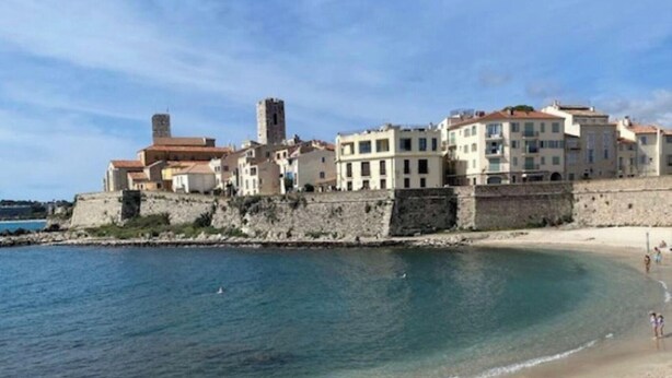 A coastal town with historic buildings, a beach, and a stone wall. - Roseraie Apartment with Private Pool, Wi-Fi, and Air Conditioning (Antibes)