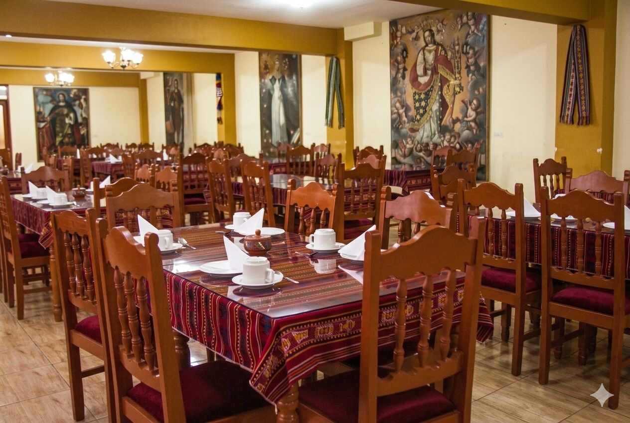 A dining area with multiple tables and chairs, each set with white plates, bowls, and cups.