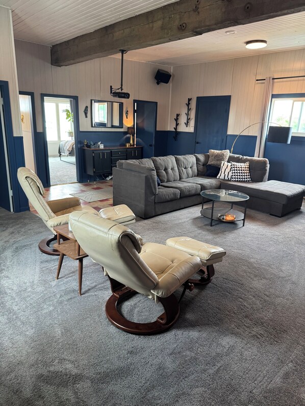 A living room with a sectional sofa, a chaise lounge, a coffee table, and a TV.