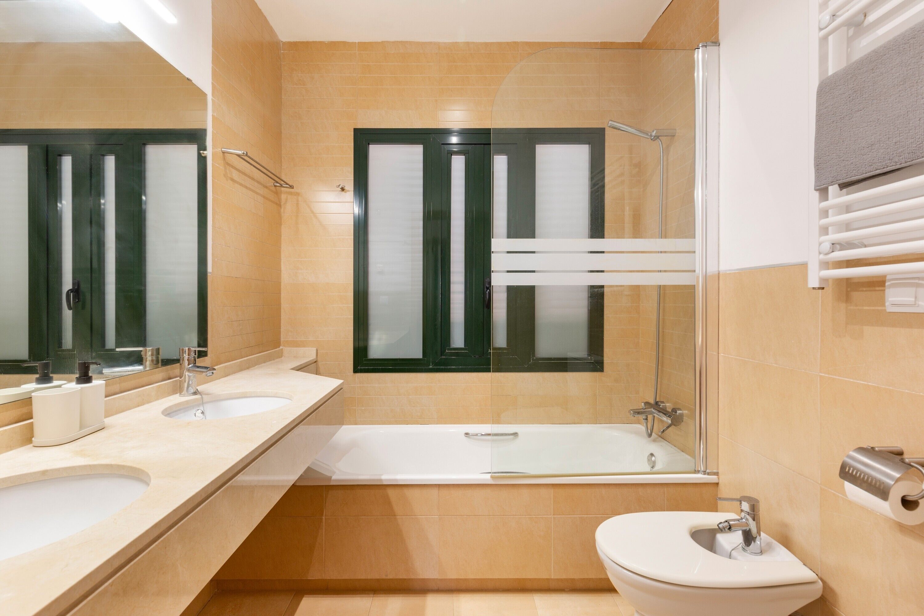 A bathroom with two sinks, a bathtub, a toilet, and a shower.