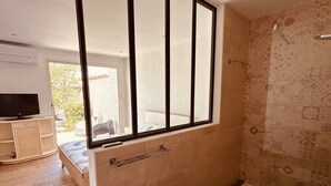 Een badkamer met bad, toilet en douche.