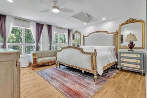 A bedroom with a bed, a sofa, a dresser, a mirror, and a ceiling fan. - Luxe 5BR Atlanta Retreat in Buckhead (Atlanta)