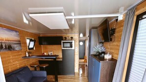 Un intérieur de camping-car compact comprenant un coin cuisine, un canapé et un espace repas.