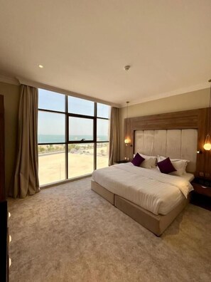 Un dormitorio espacioso con una cama grande, vistas al mar y un diseño moderno.