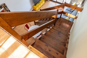 A wooden staircase with a bench, a yellow cabinet, and a sofa in the background. - Apartment Luna, modern, 100 m from the sea (L'Escala)