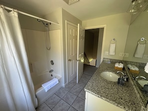 Une salle de bain équipée d’une baignoire, d’une douche, d’un lavabo et d’un miroir.