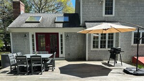 A patio with a table and chairs, a barbecue grill, and a covered area with an umbrella. - Spacious 4 bedroom PRIVATE HOME
centrally located to all the Cape has to offer (Barnstable)