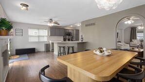 Una cucina moderna con isola centrale, sgabelli da bar e un tavolo da pranzo.