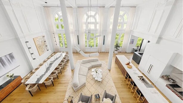 A spacious room with a long dining table, a seating area with sofas, and a kitchen area. - 8,000 sq ft, 7BR/8.5BA triplex maisonette with 3 private entrances (New York)