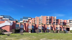 Un immeuble résidentiel à plusieurs étages, doté de balcons, d’un toit plat et surplombant un ciel dégagé.