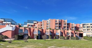A multi-story residential building with balconies, a flat roof, and a clear sky. - Cosy studio with sea & garden view - swimming pool (Sète)