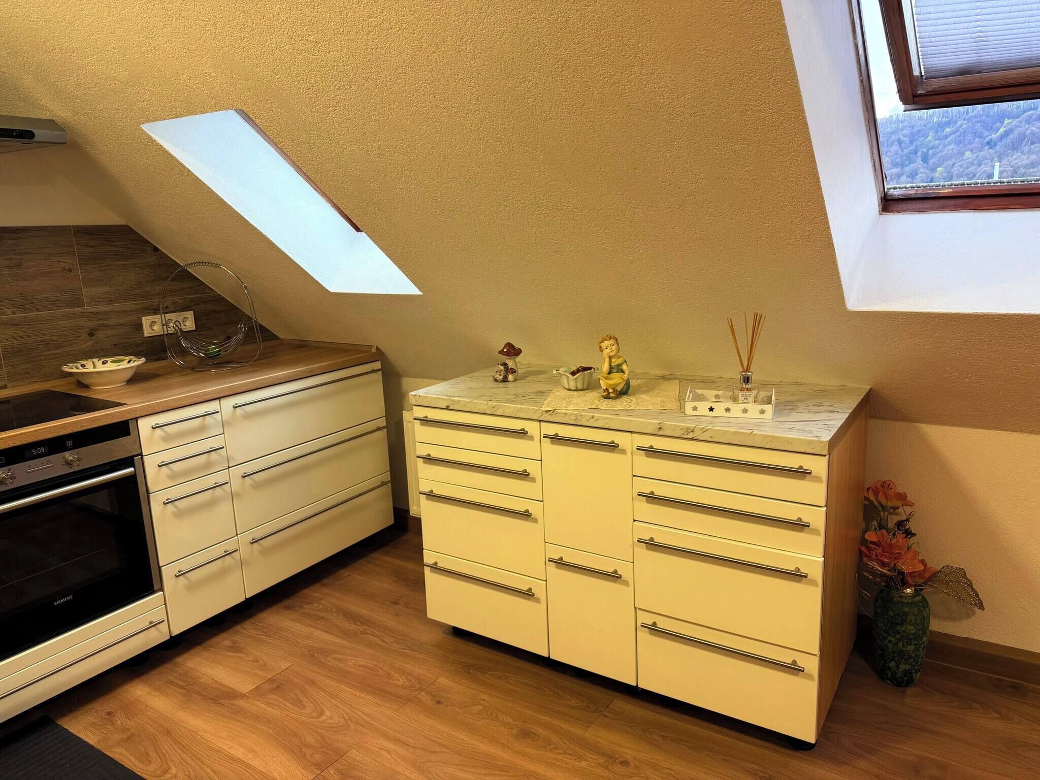 Eine Küche mit Oberlicht, einem Einbauofen und einer Marmorarbeitsplatte.
