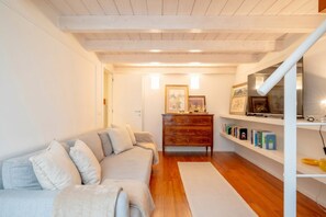 Ein gemütliches Wohnzimmer mit einer Couch, einer Holzkommode und einem Bücherregal.