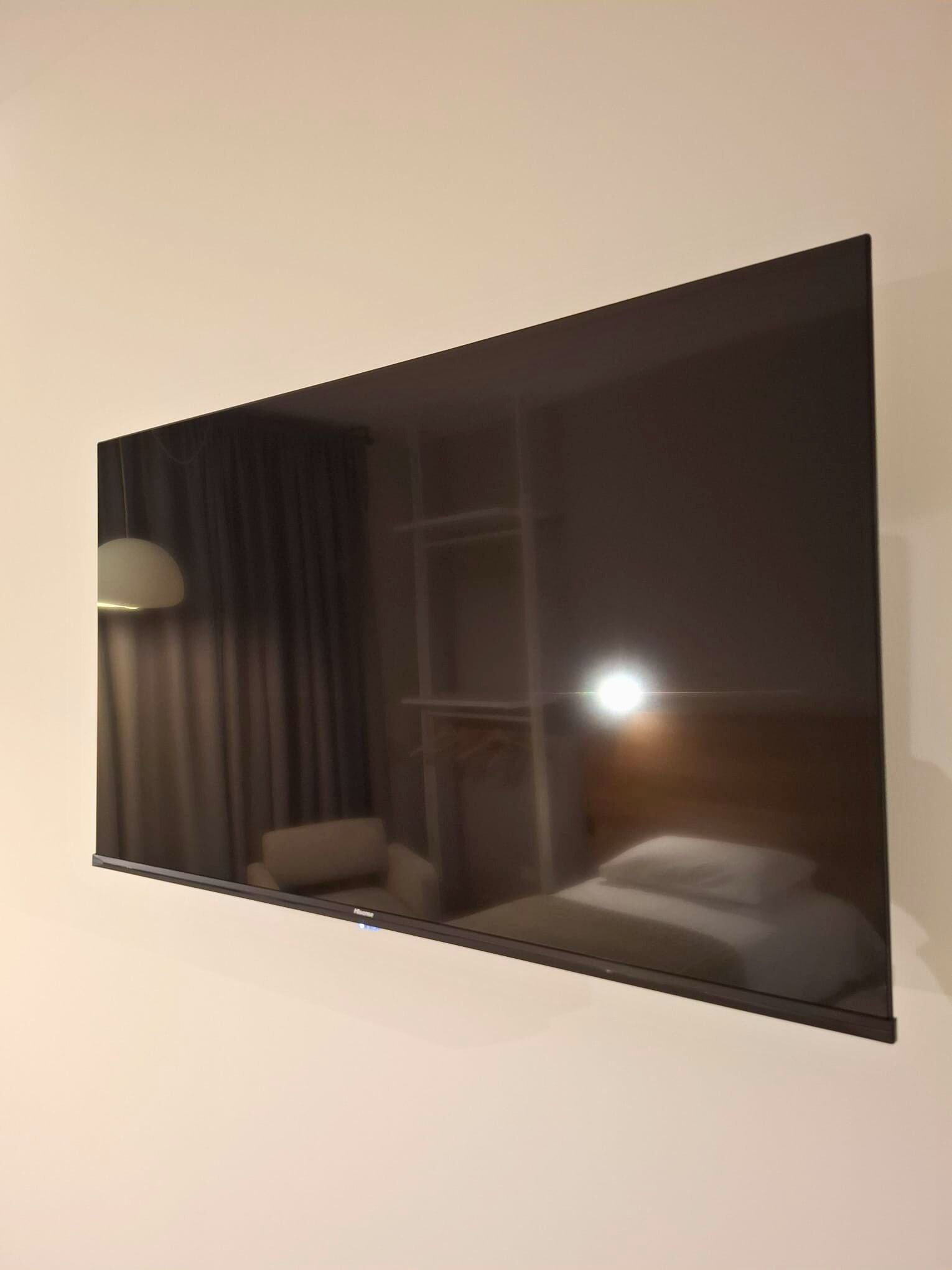 A room with a bed, a chair, a lamp, and a window.