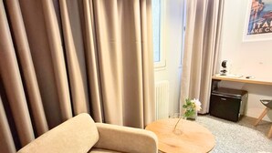 A modern hotel room with a sofa, a round coffee table, a lamp, a desk, and a radiator. - Eva Urban Rooms Centro Lecco (Lecco)