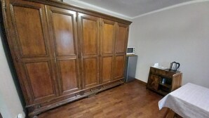 A room with a wooden wardrobe, a small table with a kettle, and a microwave on a cabinet. - Large master bedroom with private bathroom (Friuli-Venezia Giulia)