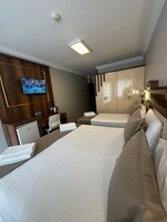 Una habitación de hotel con dos camas, televisión, minibar y armario.
