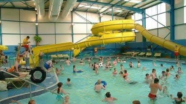 An indoor swimming pool with multiple lanes, a water slide, and a lifeguard stand. - Cabin Sleeps 6 With Wifi (Skegness)