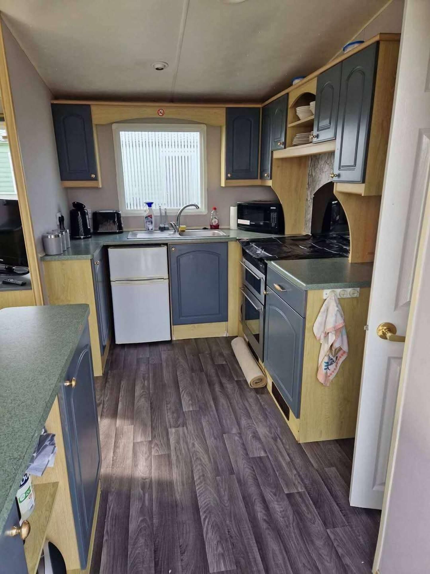 Una cocina compacta con refrigerador, microondas y estufa.