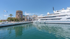 A marina with a large yacht named 'Lady Haya,' a historic tower, and a hotel named 'Hotel Riviera.' - Holiday Home 'Enjoy Puerto Banus Next To Beach' with Sea View, Wi-Fi and Air Conditioning (Marbella)