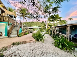 A resort with a wooden staircase, a covered walkway, and a building with a green roof. - Villa 11 Flamenco Beachfront Villa (Flamenco)