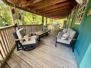 A covered outdoor seating area with wooden flooring, cushioned chairs, and tables. - Villa 11 Flamenco Beachfront Villa (Flamenco)