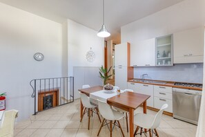 Eine moderne Küche mit weißen Schränken, einem Holzespeisetisch und einem Edelstahl-Geschirrspüler.