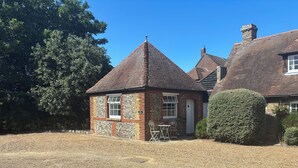 A traditional brick house with a tiled roof, a stone wall, and a small garden area with a gravel path. - Manston Court Accommodations.  3 attached properties.  Sleeps up to 22 guests (Ramsgate)