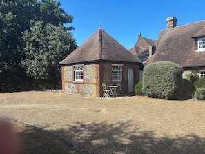 A traditional brick house with a tiled roof, a stone wall, and a small garden area with a gravel path. - Manston Court Accommodations.  3 attached properties.  Sleeps up to 22 guests (Ramsgate)