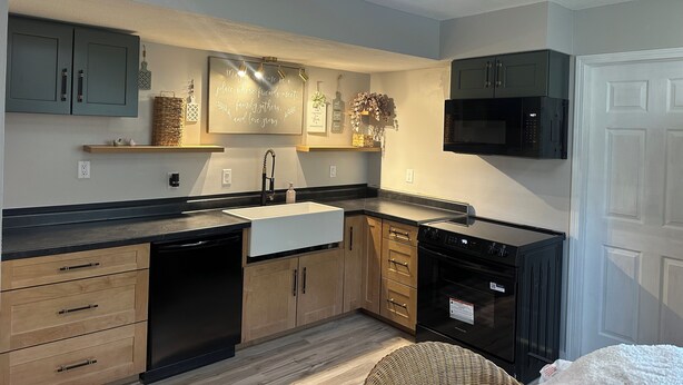 A modern kitchen with built-in appliances, wooden cabinets, and a decorative wall piece. - Nice 2-bedroom in charming Smithville near Lake. Onsite boat parking available. (Smithville)