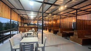 An indoor dining area with tables and chairs, a counter, and a television. - Villas en Guatape  (Guatape)