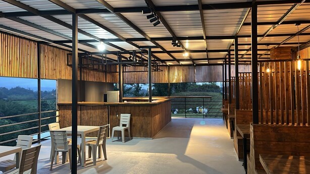 A modern interior with a bar area, seating, and a view of the outdoors. - Villas en Guatape  (Guatape)