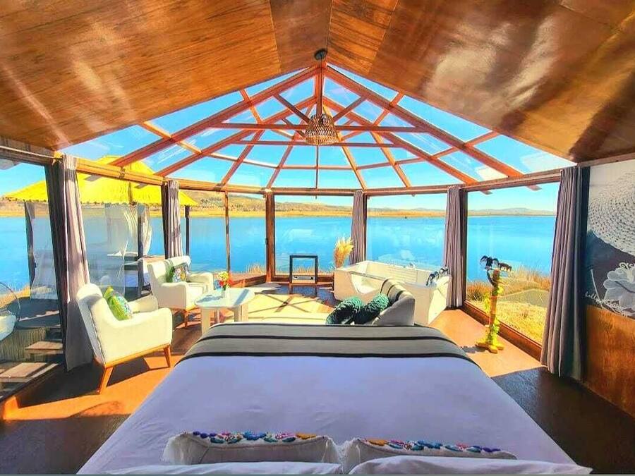 Un dormitorio con una cama grande, techo de cristal y vista al mar.