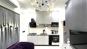 Una cocina moderna con armarios blancos, un microondas negro y un horno integrado.