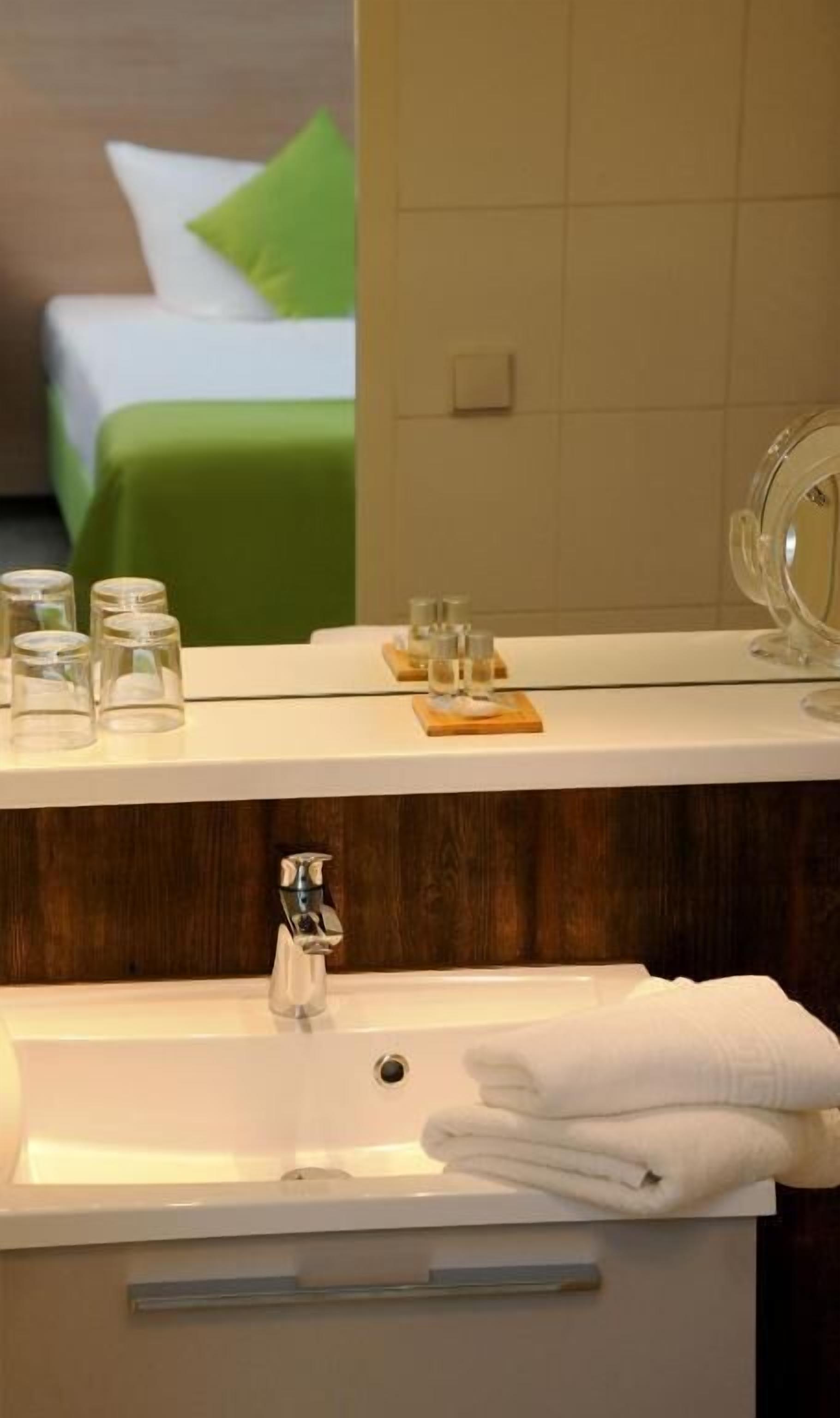 A bathroom with a sink, mirror, and toiletries.