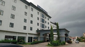A multi-story hotel with a sign reading 'The Aldershot Hotel & Suites.'