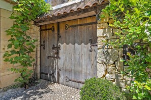 A rustic wooden gate with metal hinges and a stone wall. - Holiday Home “La Maison de Marie” with Shared Terrace, Wi-Fi & Air Conditioning (Domme)