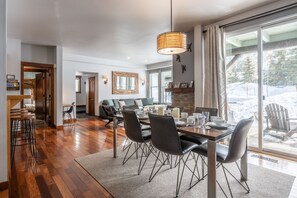 Ein Essbereich mit einem Holztisch, schwarzen Stühlen und einer Pendelleuchte.