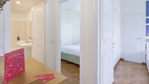 A hotel room with a bathroom, a bed, and a wooden floor. - Camogli Sea and Valley View by Wonderful Italy (Camogli)