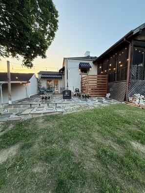A backyard with a patio, outdoor seating, a grill, and string lights. - Art Deco Oasis - Pool Table, bar, fire pit, TV’s (Affton)