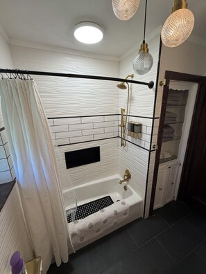A modern bathroom with a freestanding bathtub, a showerhead, and a towel rack. - Art Deco Oasis - Pool Table, bar, fire pit, TV’s (Affton)