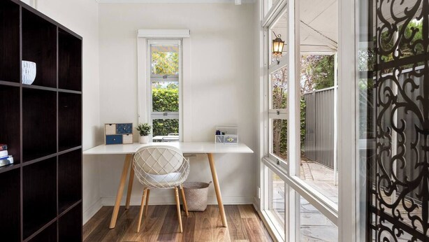 Un espace de travail comprenant un bureau, une chaise et une étagère.