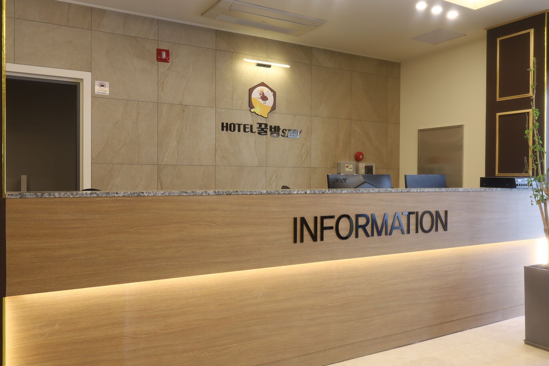 A hotel reception desk with a wooden counter, a sign reading 'HOTEL', and a computer on the desk.