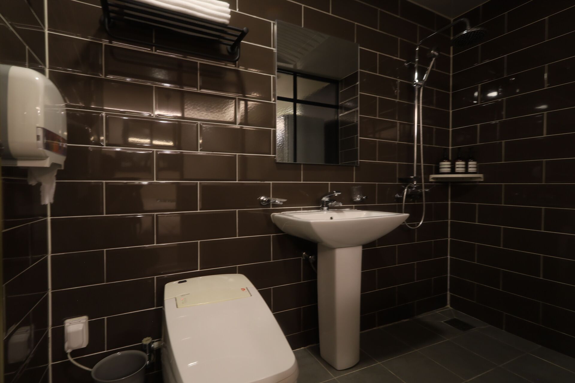 A bathroom with a white sink, a mirror, a towel rack, and a shower.