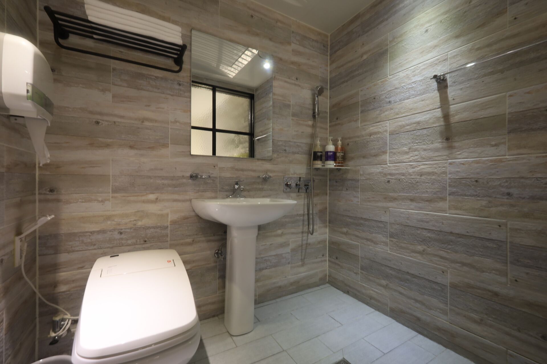 Un baño con inodoro, lavamanos y ducha.